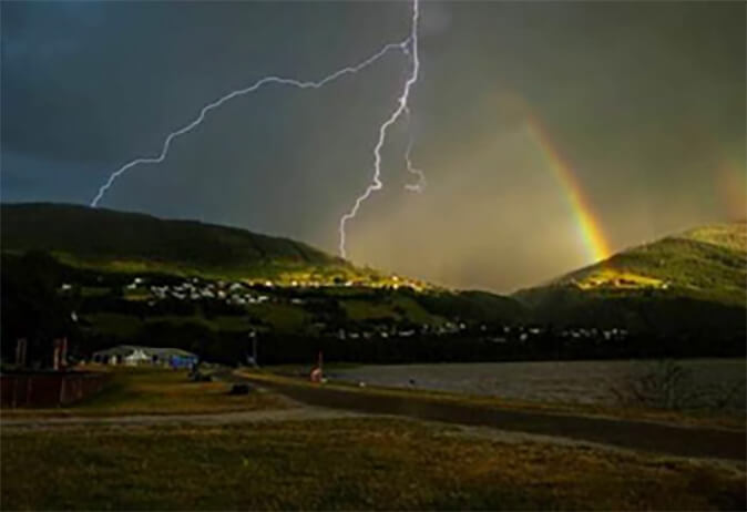 Landscape scene of lightning and rainbow