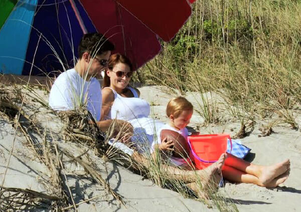 Young couple with baby on beach, advent image 4